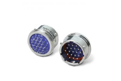 Detoronics DFC series circular connectors with a silver finish. One connector shows a blue, labeled pin insert; the other, a red insert with the same pins.